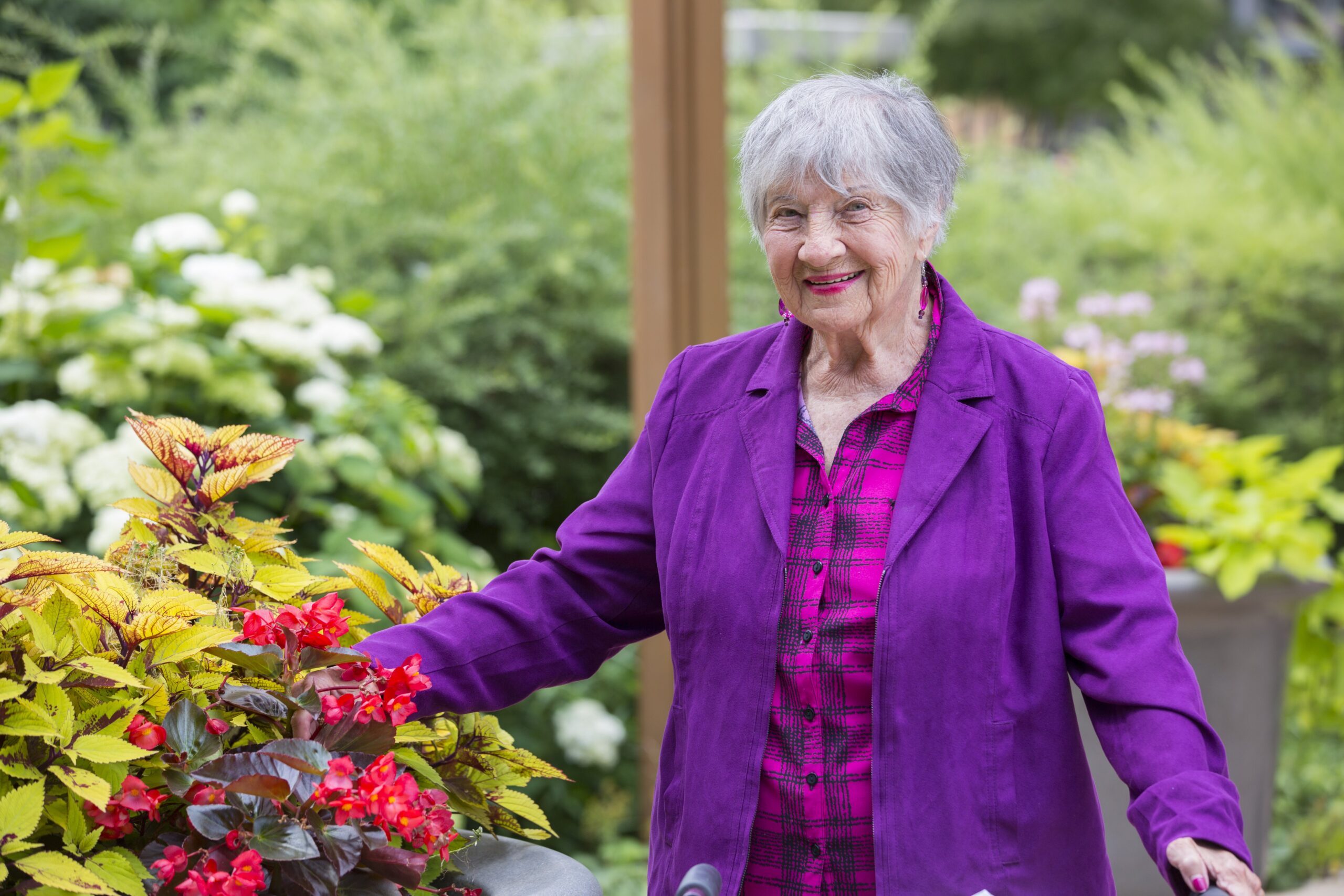 Woman walks through flower garden looking happy