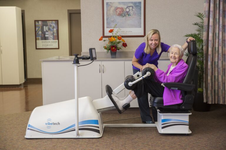 Resident working with rehab staff in an exercise chair