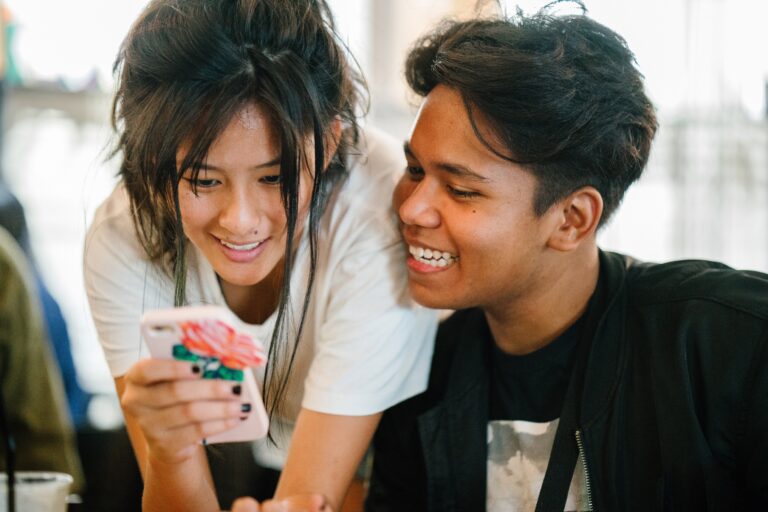 two teens looking at a phone together