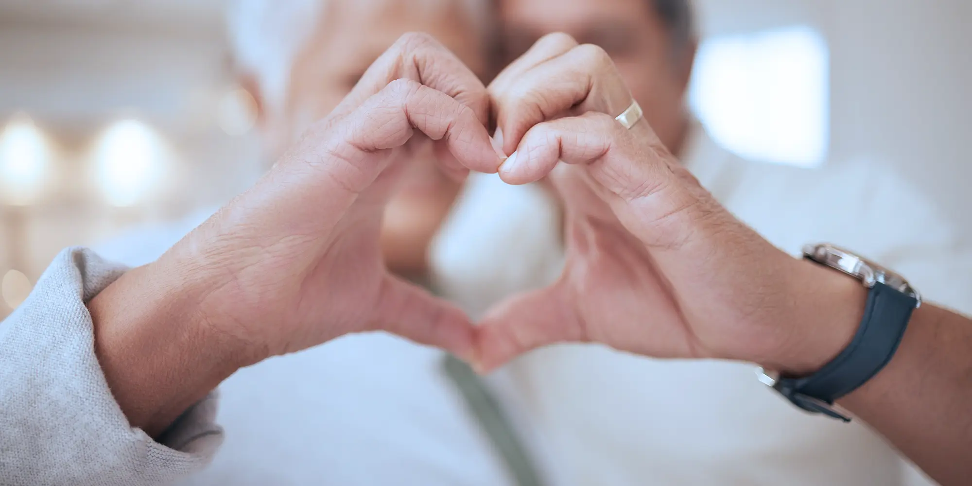 man and woman holding hands together creating heart
