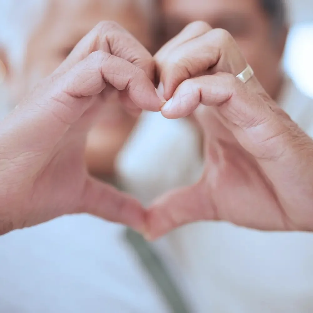 adult and senior hands making heart scaled